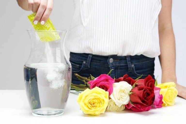 Eine Frau gibt Zucker ins Blumenwasser