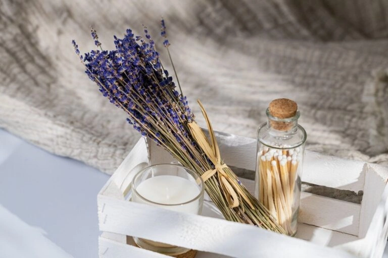 Getrockneter Lavendel als Tischdeko neben einer Kerze im Glas, ruhig arrangiert ohne zusätzliche Dekoration