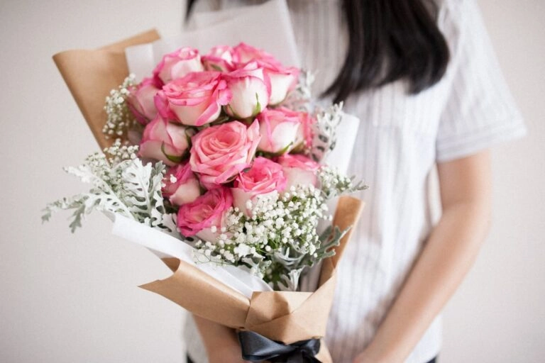 Gebundener Strauß zur Geburtsblume als Geschenk, in Papier gewickelt und bereit zur Übergabe